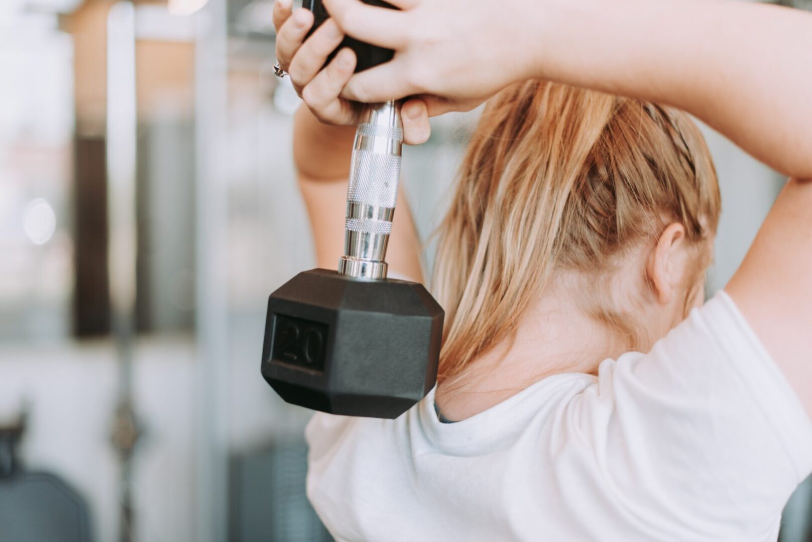 A person holding a black and silver dumbbell