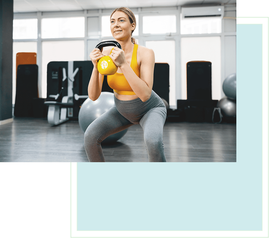 A woman is squatting with a yellow dumbbell.