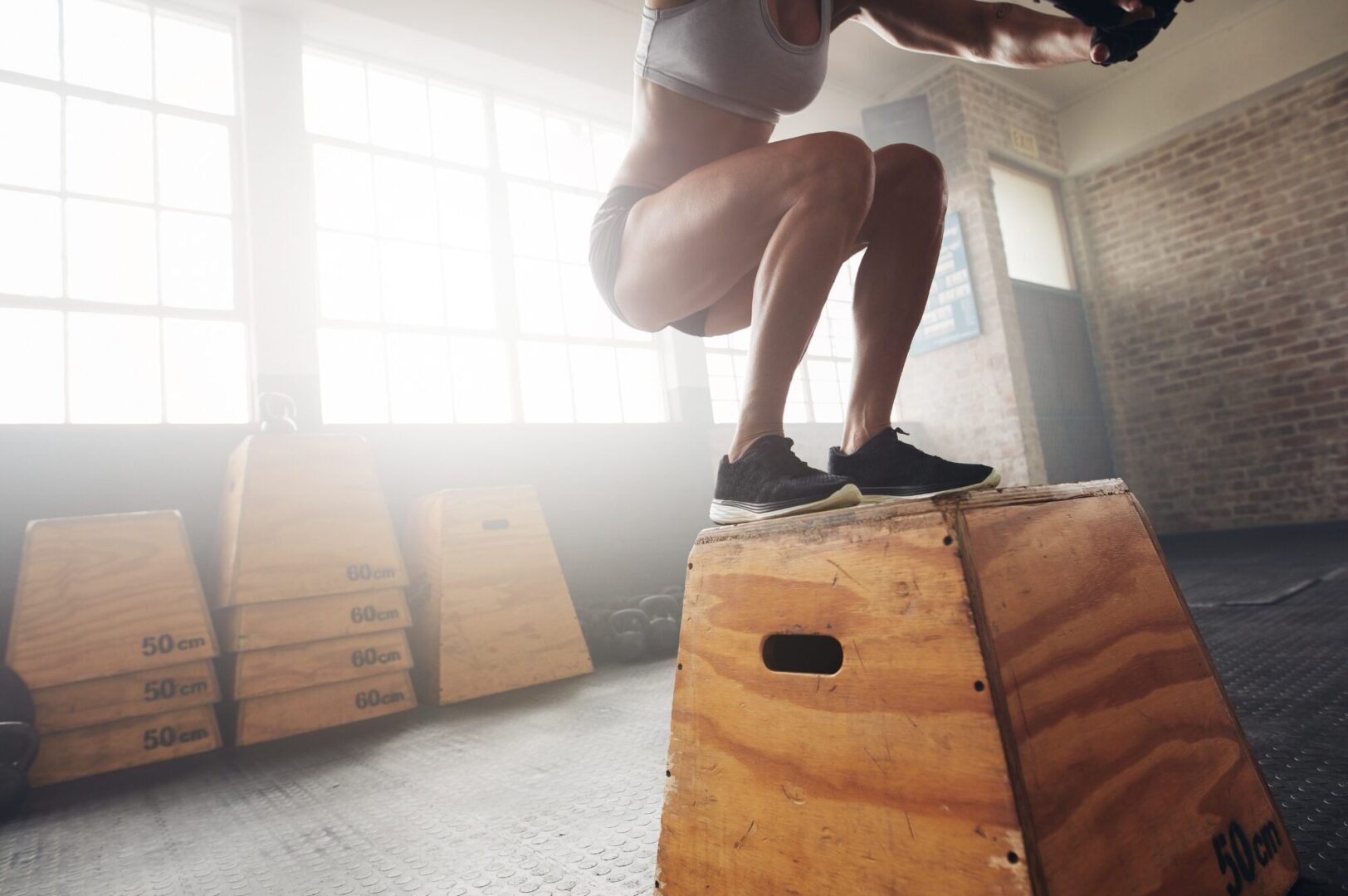 A woman jumping over an obstacle in the air.